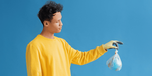 A man holding a clear plastic bag with a little globe inside.