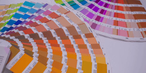 Pantone colour charts printed out and laid on a table.