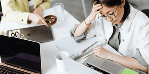 A stressed woman looking down on her laptop. 