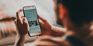 A man looking at his Samsung phone searching something on Google. 