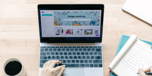 A person browsing Canva on a laptop with their hand resting on the keyboard. 