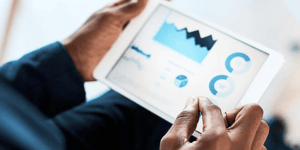 A person holding an iPad looking at data visualisation graphs. 