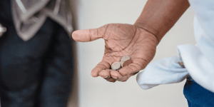 An open hand holding some coins from an empty pocket.