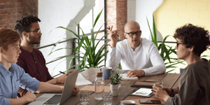 A group of colleagues around a table brainstorming and having a discussion. 