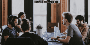 Group of people around a table brainstorming ideas.