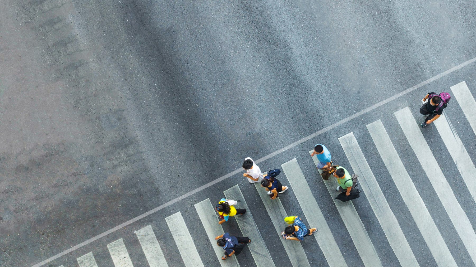 An overhead image of people walking across a street crossing
